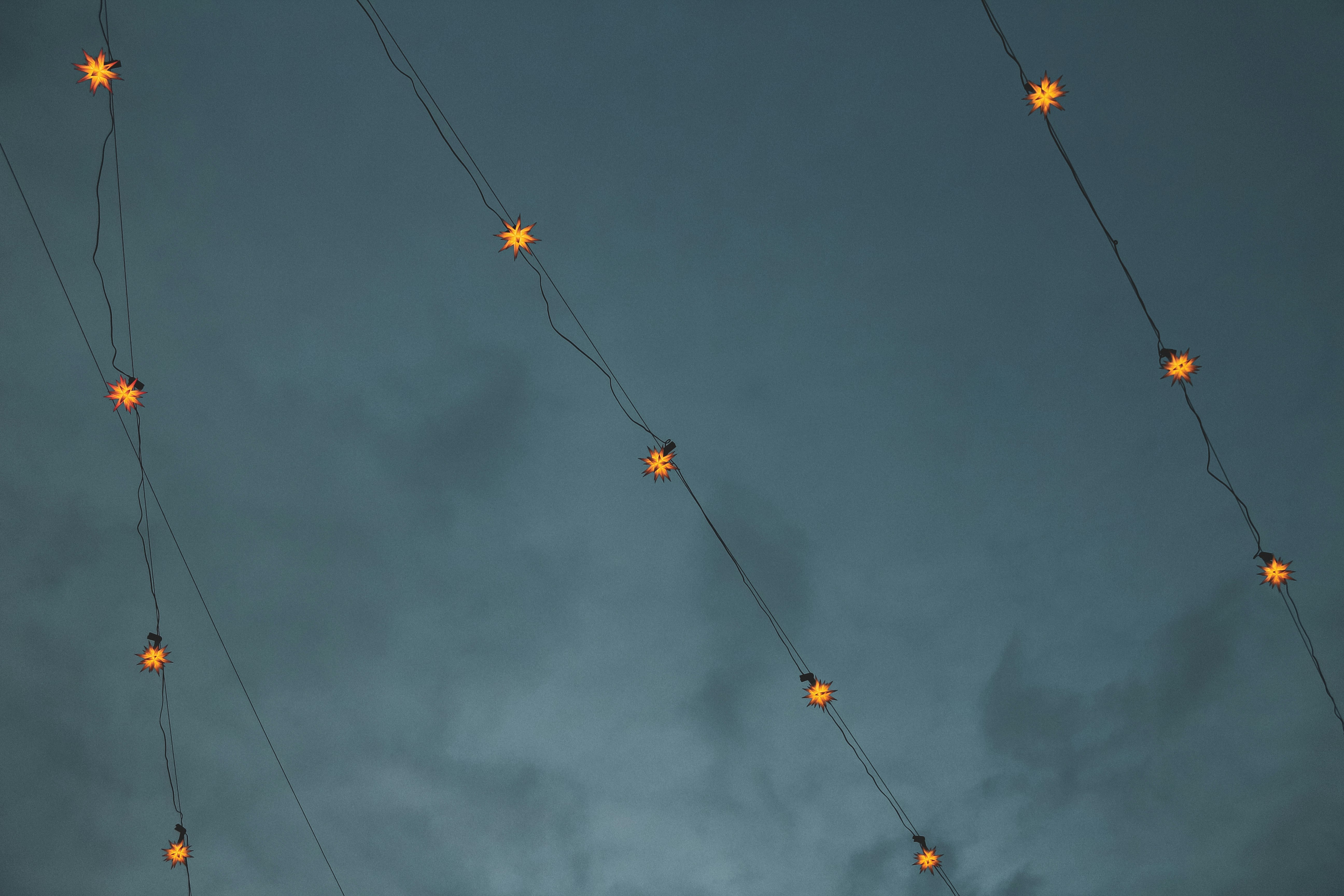 yellow and orange string lights under dark clouds
